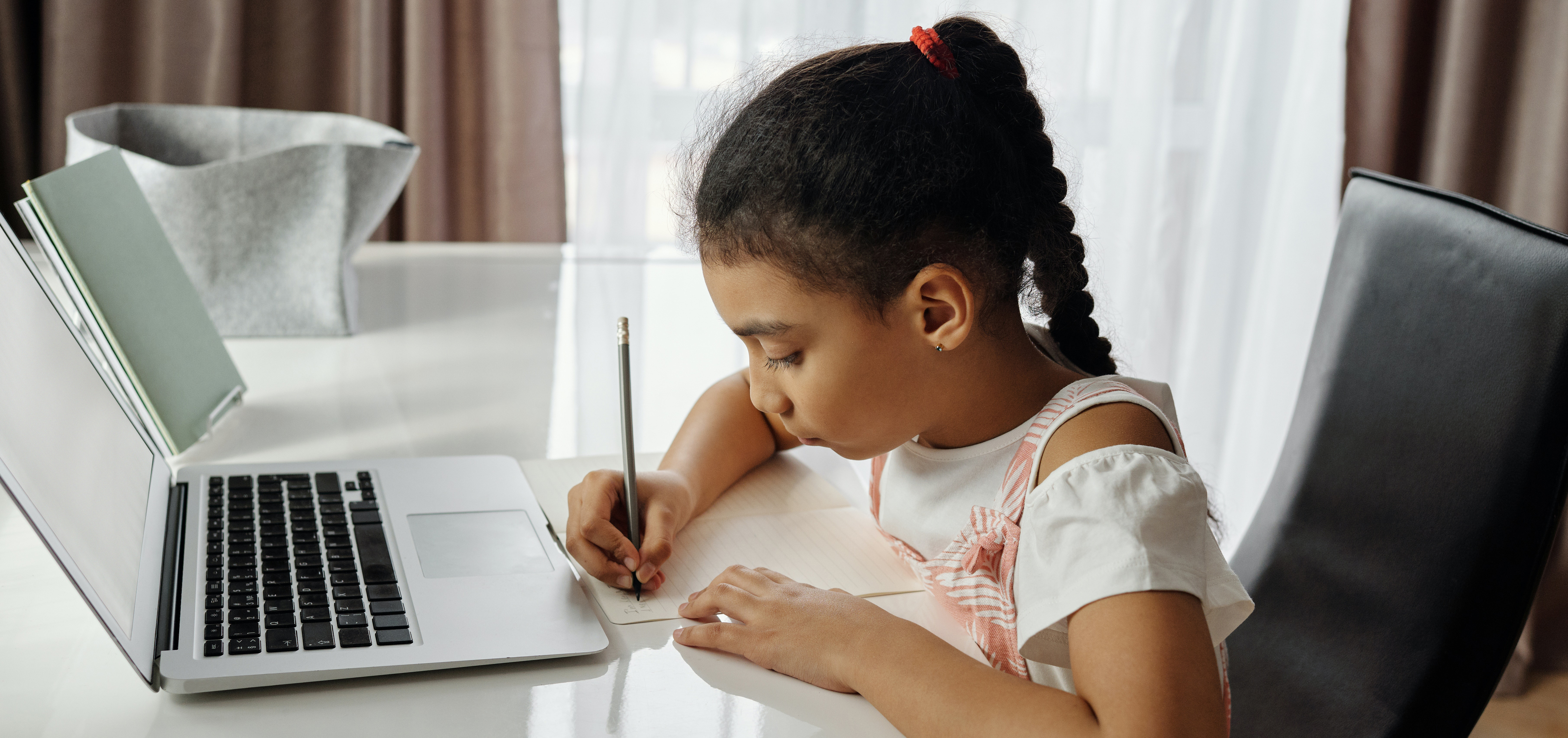 Girl working on her homework in front of a computer